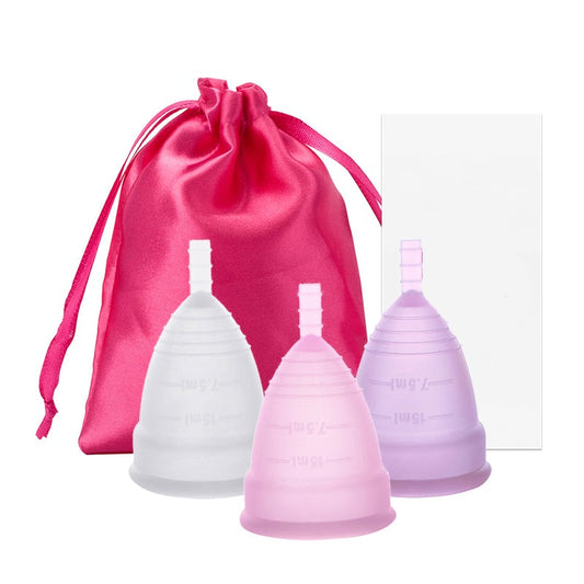 A collection of menstrual cups in various colors presented next to a pink storage pouch